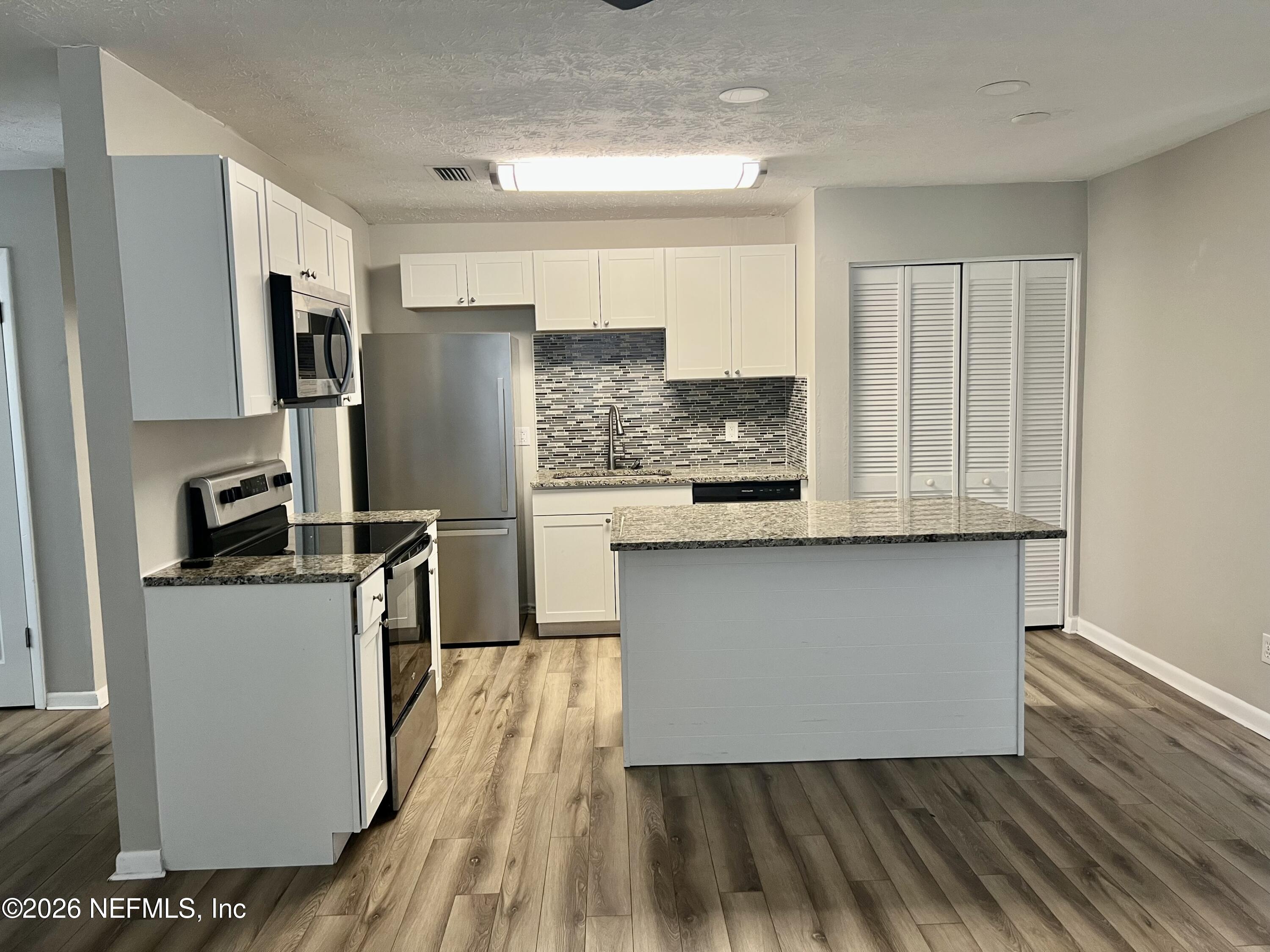 10964 Bacall Road West Jacksonville, FL 32218 - Photo 7 of 19 a kitchen with stainless steel appliances granite countertop a refrigerator a stove and a sink