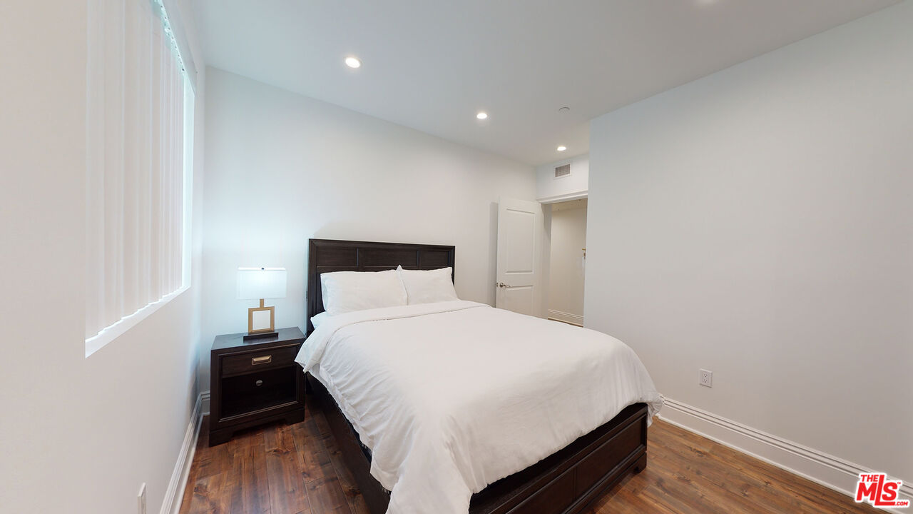 907 South Shenandoah Street, Unit 101 Los Angeles, CA 90035 - Photo 13 of 39 a bedroom with a bed and wooden floor