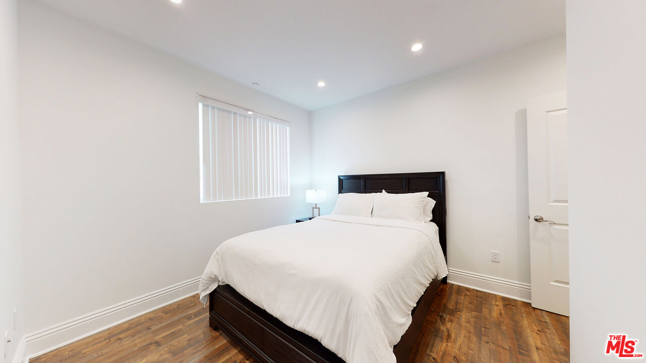 907 South Shenandoah Street, Unit 101 Los Angeles, CA 90035 - Photo 15 of 39 a bedroom with a bed and wooden floor