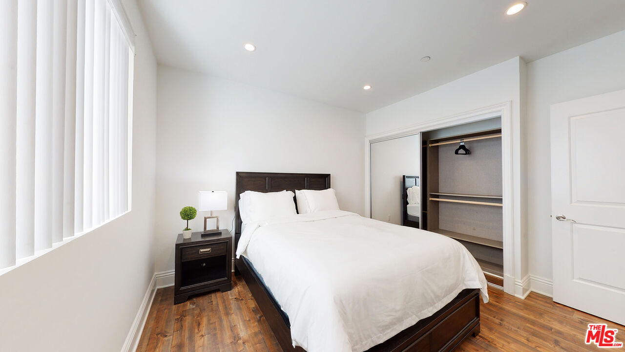 907 South Shenandoah Street, Unit 101 Los Angeles, CA 90035 - Photo 17 of 39 a bedroom with a bed and wooden floor