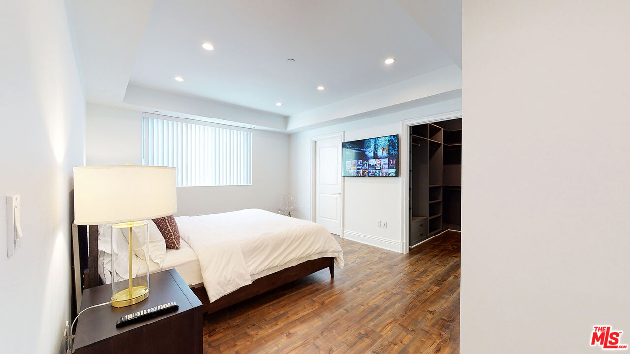 907 South Shenandoah Street, Unit 101 Los Angeles, CA 90035 - Photo 22 of 39 a bedroom with a bed and a refrigerator