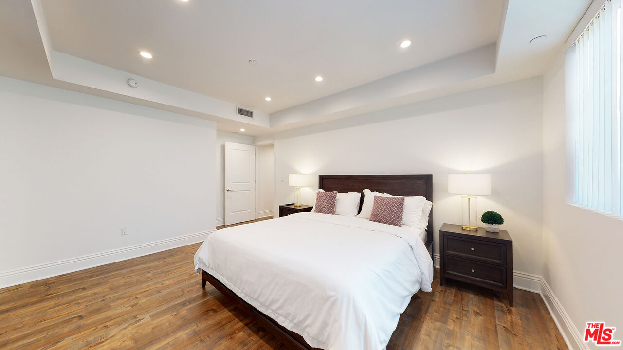 907 South Shenandoah Street, Unit 101 Los Angeles, CA 90035 - Photo 24 of 39 a bedroom with a bed and wooden floor