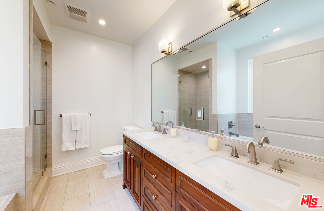 907 South Shenandoah Street, Unit 101 Los Angeles, CA 90035 - Photo 25 of 39 a bathroom with a double vanity sink toilet and shower