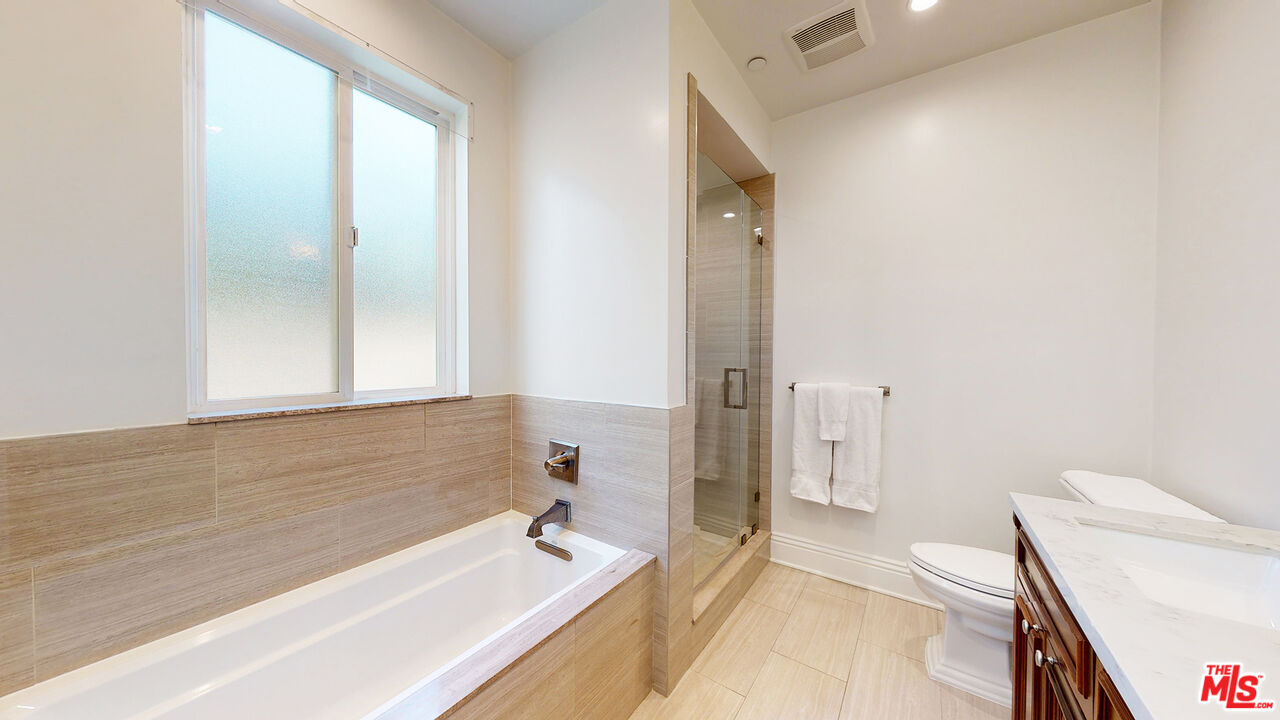 907 South Shenandoah Street, Unit 101 Los Angeles, CA 90035 - Photo 28 of 39 a bathroom with a tub a sink and a large mirror
