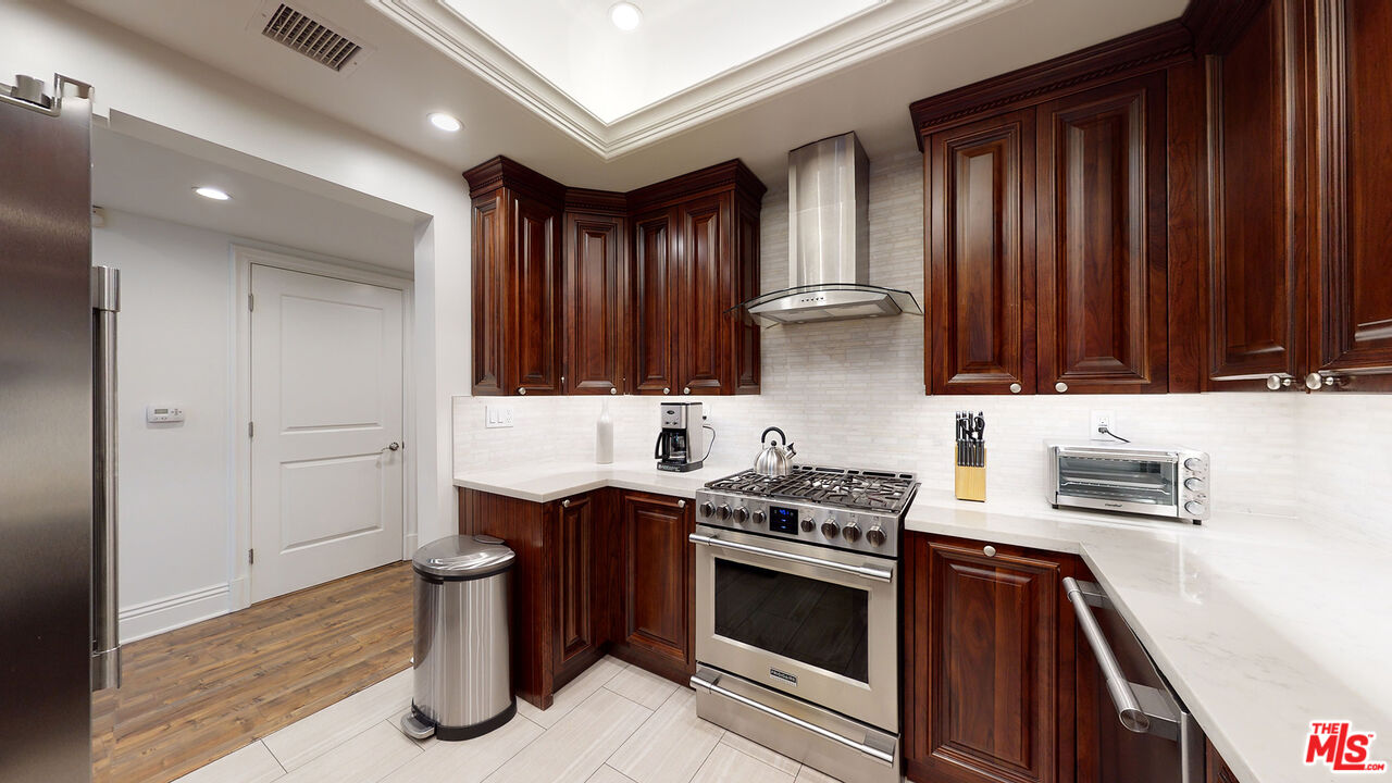 907 South Shenandoah Street, Unit 101 Los Angeles, CA 90035 - Photo 9 of 39 a kitchen with stainless steel appliances a stove and a refrigerator