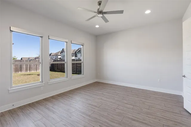 an empty room with a ceiling fan and a window