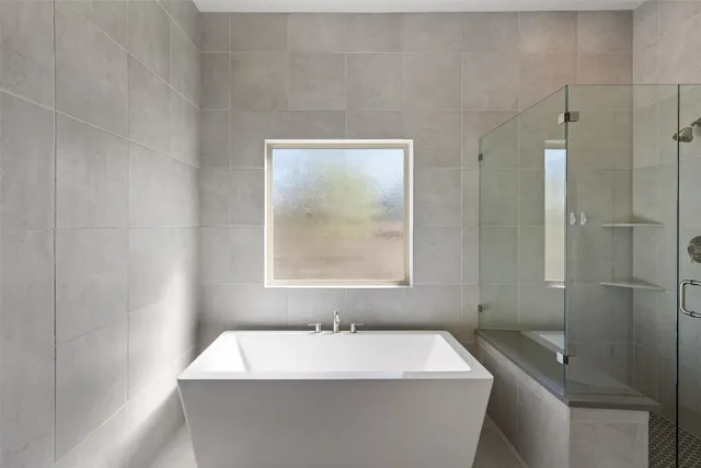 an empty room with a chandelier fan and windows