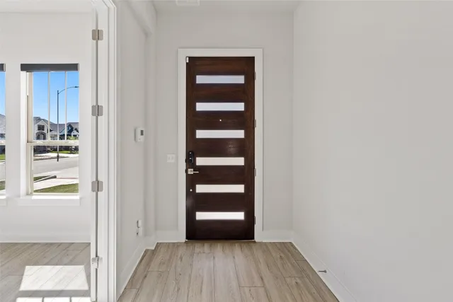 a large kitchen with stainless steel appliances a large counter top a stove and a wooden floors