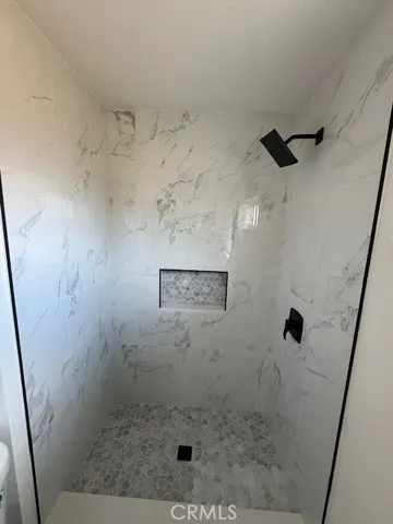 an empty room with wooden floor ceiling fan and windows