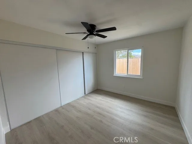 an empty room with a window and a fan