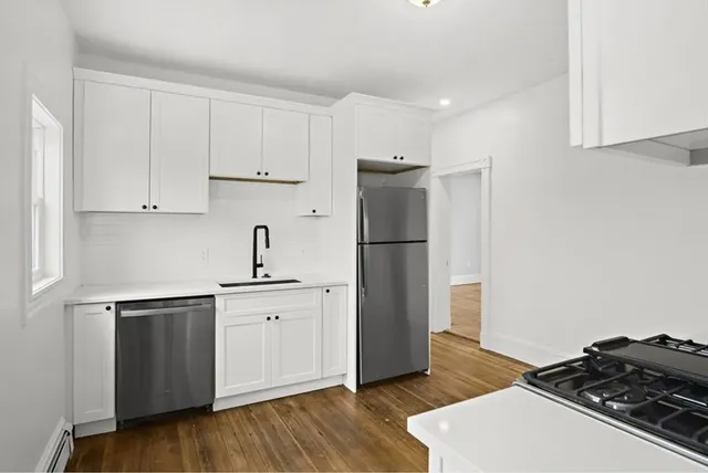 a kitchen with white cabinets and stainless steel appliances