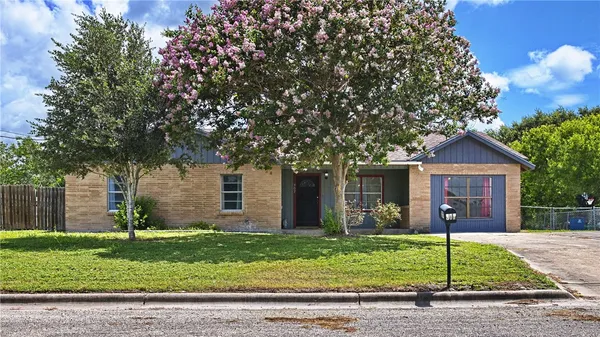 a front view of a house with a garden and plants