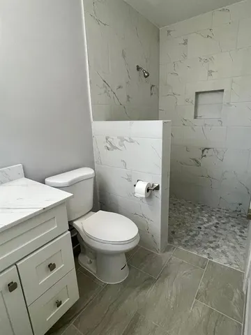 a white toilet sitting next to a bathroom sink