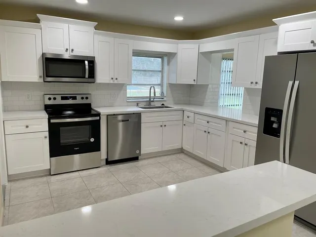 a kitchen with stainless steel appliances a stove sink microwave and refrigerator