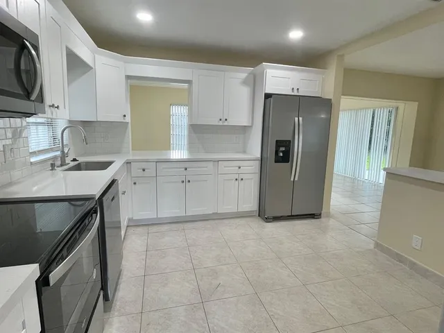 a kitchen with a sink a refrigerator and cabinets
