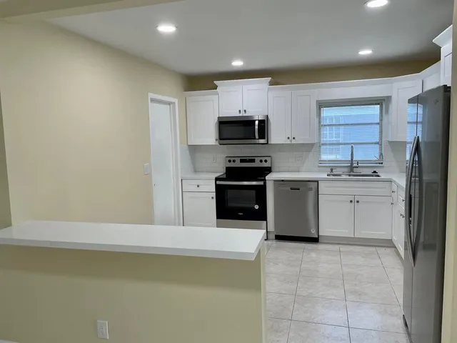 a kitchen with a sink a stove a refrigerator and a microwave