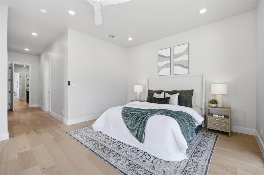 4615 Rusk Avenue Dallas, TX 75204 - Photo 25 of 40 a spacious bedroom with a bed and a chandelier