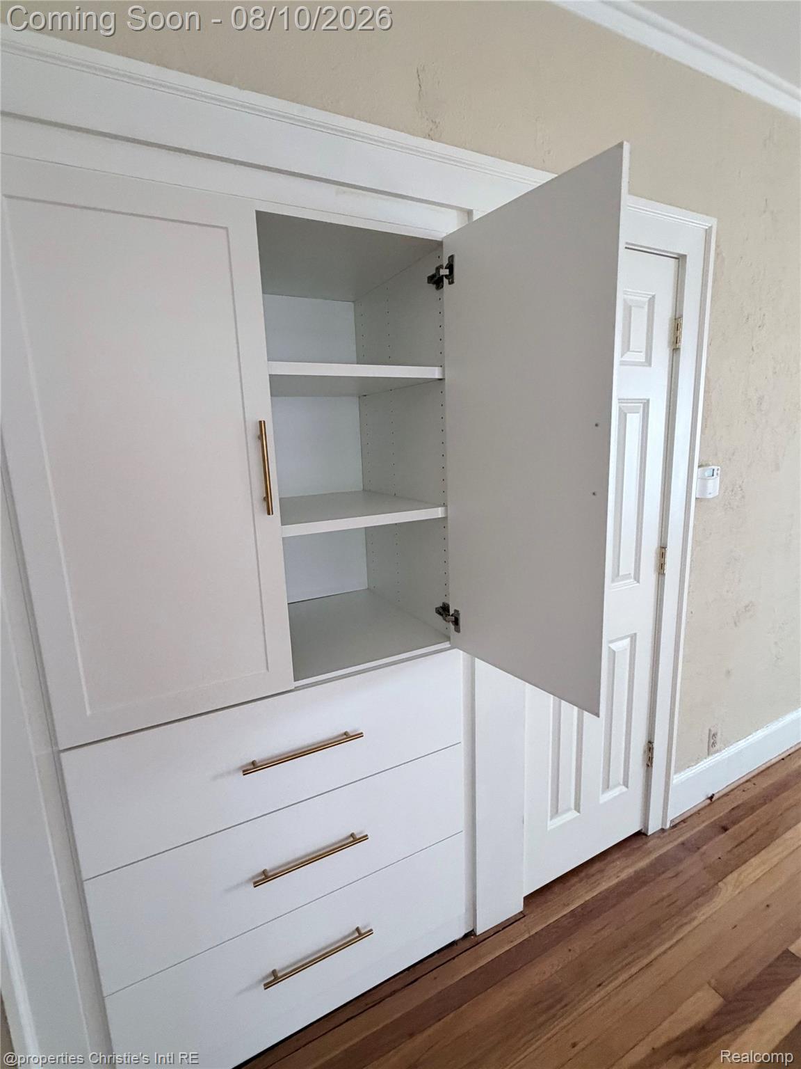 858 Nottingham Road Grosse Pointe, MI 48230 - Photo 4 of 16 Built-in wardrobe featuring dual white shaker-style doors with brushed brass hardware, three interior shelves, and three lower drawers with full-extension glides
