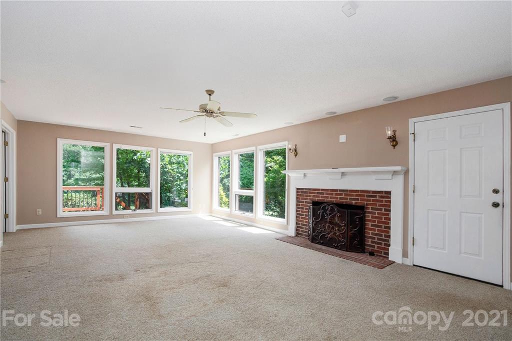 8281 Fairfield Forest Road Denver, NC 28037 - Photo 8 of 30 a view of an empty room with a fireplace and a window