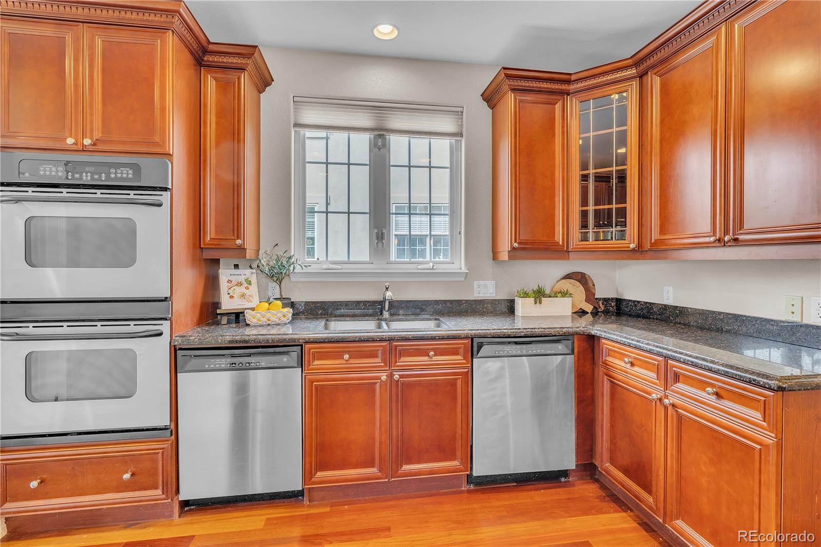 8053 East Maple Avenue Denver, CO 80230 - Photo 15 of 49 a kitchen with stainless steel appliances granite countertop a stove a sink and a microwave