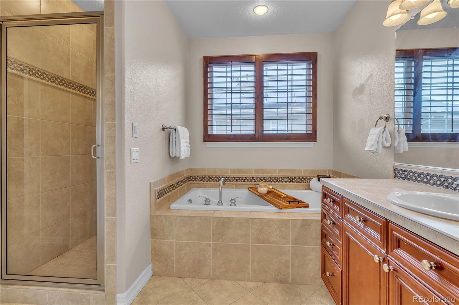 8053 East Maple Avenue Denver, CO 80230 - Photo 25 of 49 a bathroom with a tub sink and mirror