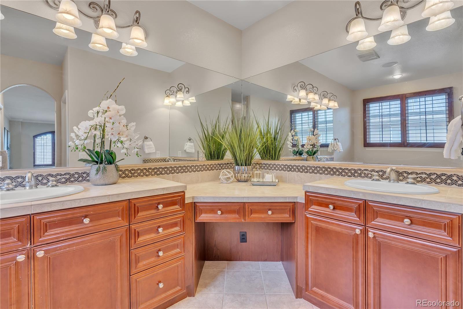 8053 East Maple Avenue Denver, CO 80230 - Photo 26 of 49 a bathroom with a granite countertop double vanity sink a window and a mirror