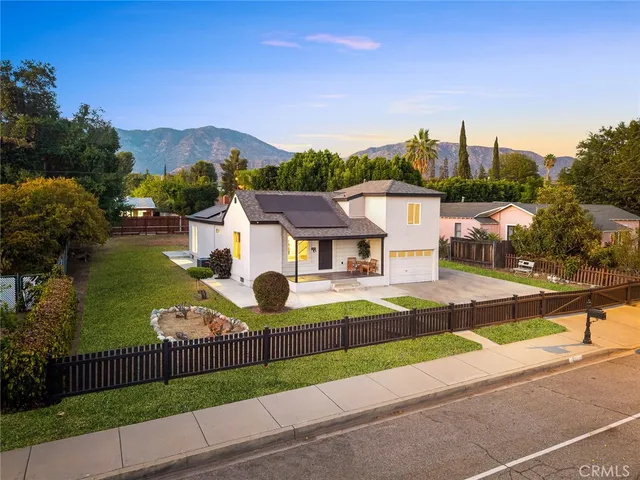 a view of a house with a yard and a street