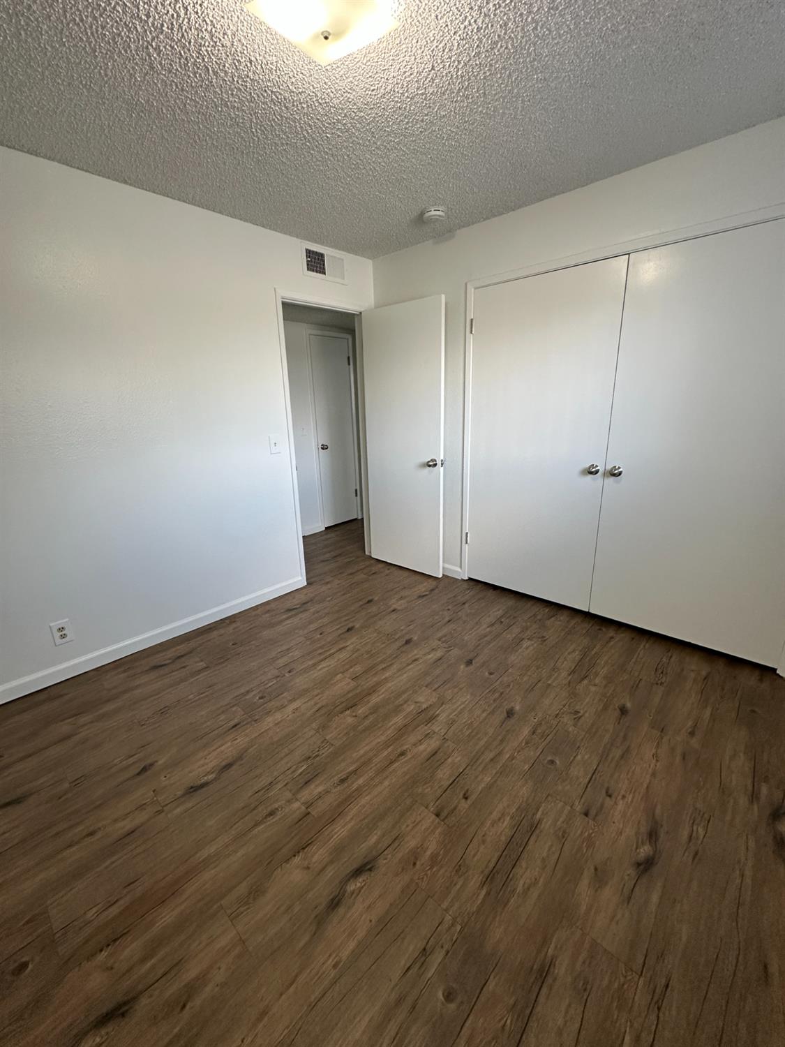 1069 Cherry Lane, Unit D Clovis, CA 93612 - Photo 13 of 18 a view of an empty room with wooden floor