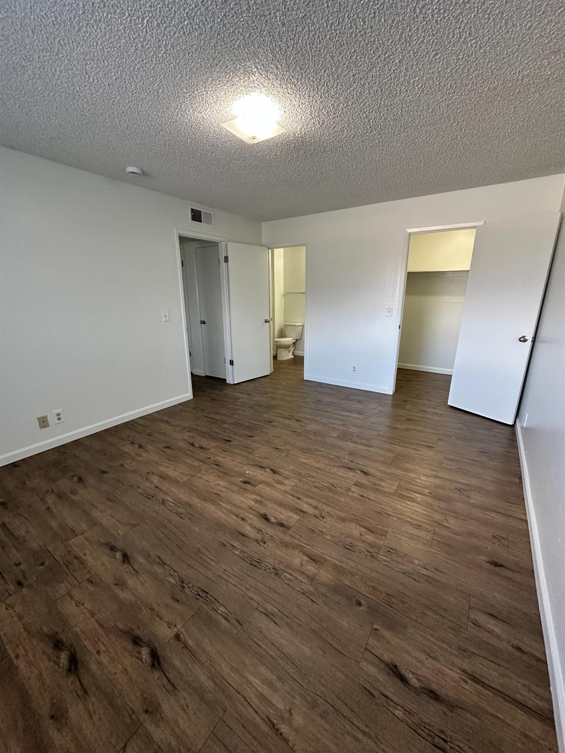 1069 Cherry Lane, Unit D Clovis, CA 93612 - Photo 15 of 18 an empty room with wooden floor and windows