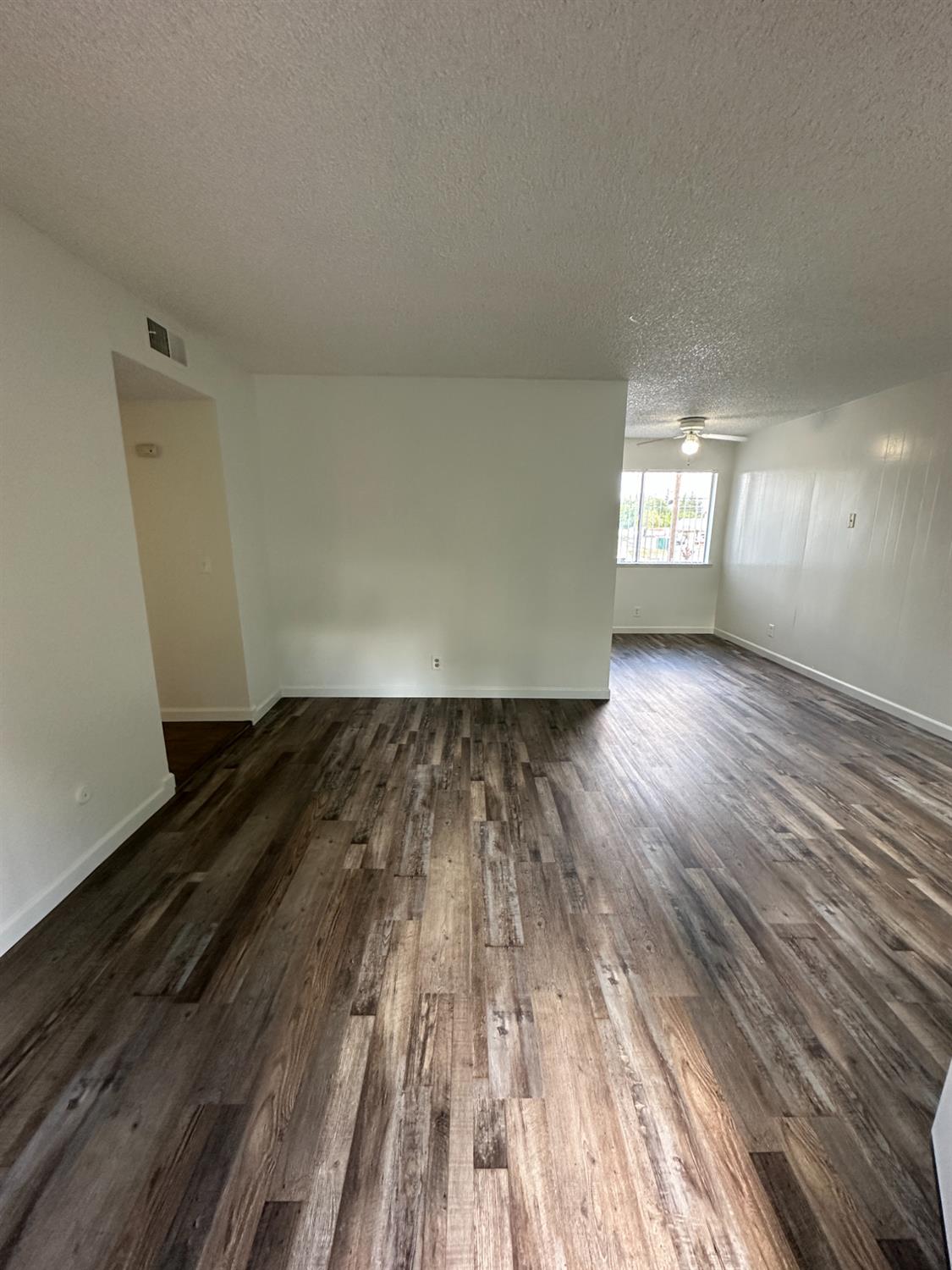 1069 Cherry Lane, Unit D Clovis, CA 93612 - Photo 2 of 18 a view of empty room with wooden floor and window
