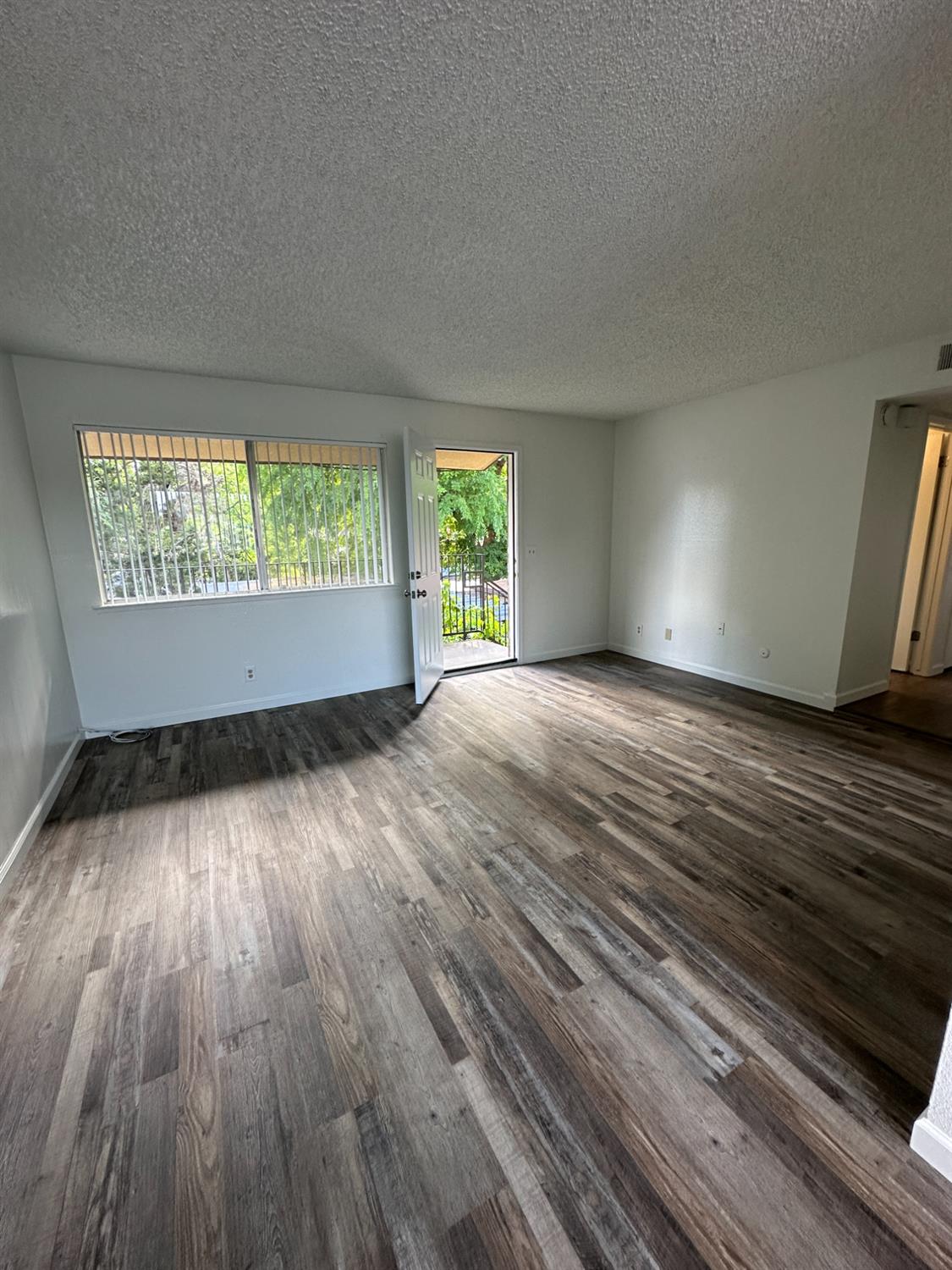 1069 Cherry Lane, Unit D Clovis, CA 93612 - Photo 4 of 18 an empty room with wooden floor and windows