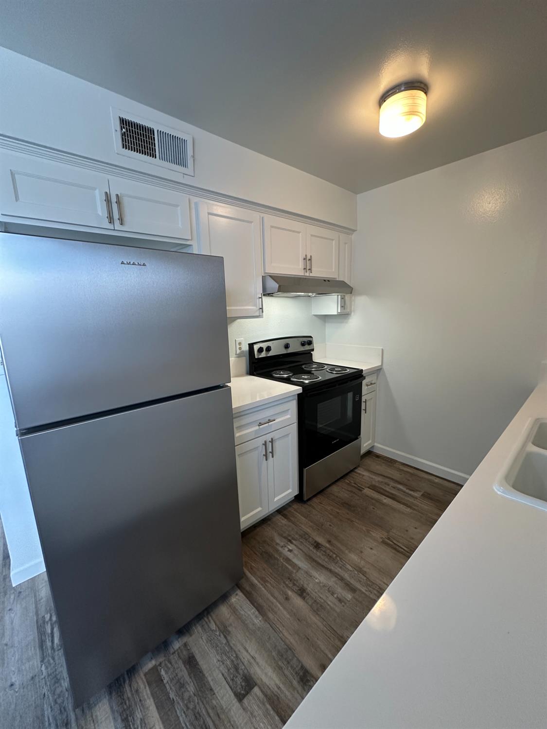 1069 Cherry Lane, Unit D Clovis, CA 93612 - Photo 6 of 18 a kitchen with a refrigerator and a stove top oven