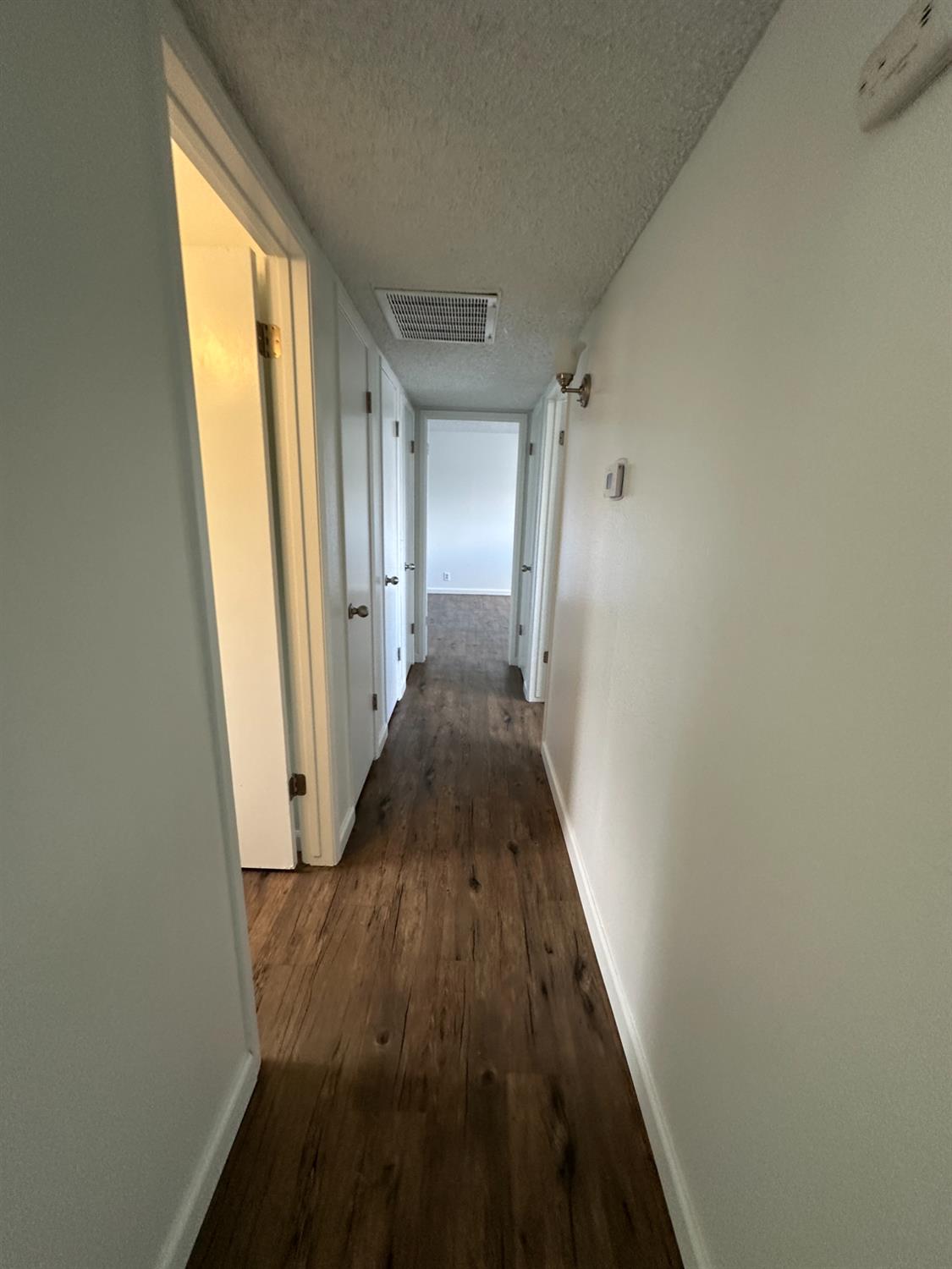 1069 Cherry Lane, Unit D Clovis, CA 93612 - Photo 9 of 18 a view of a hallway with wooden floor and staircase