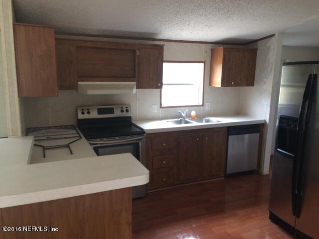 174 Gorbutt Road Crescent City, FL 32112 - Photo 10 of 13 a kitchen with a sink a stove and refrigerator