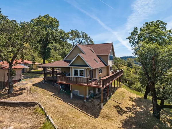 an aerial view of a house with a yard patio and deck