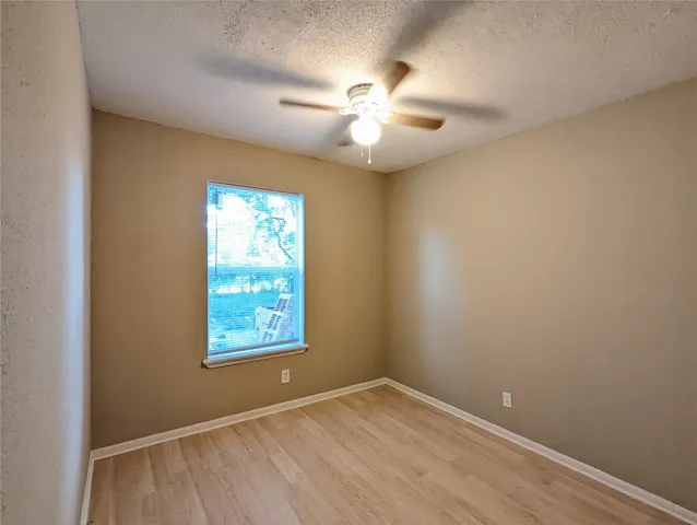 an empty room with windows and fan