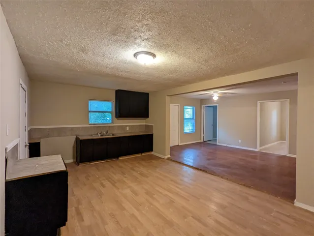 a living room with stainless steel appliances kitchen island granite countertop a refrigerator stove and microwave