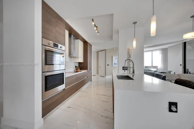 a large white kitchen with a large counter top appliances and cabinets