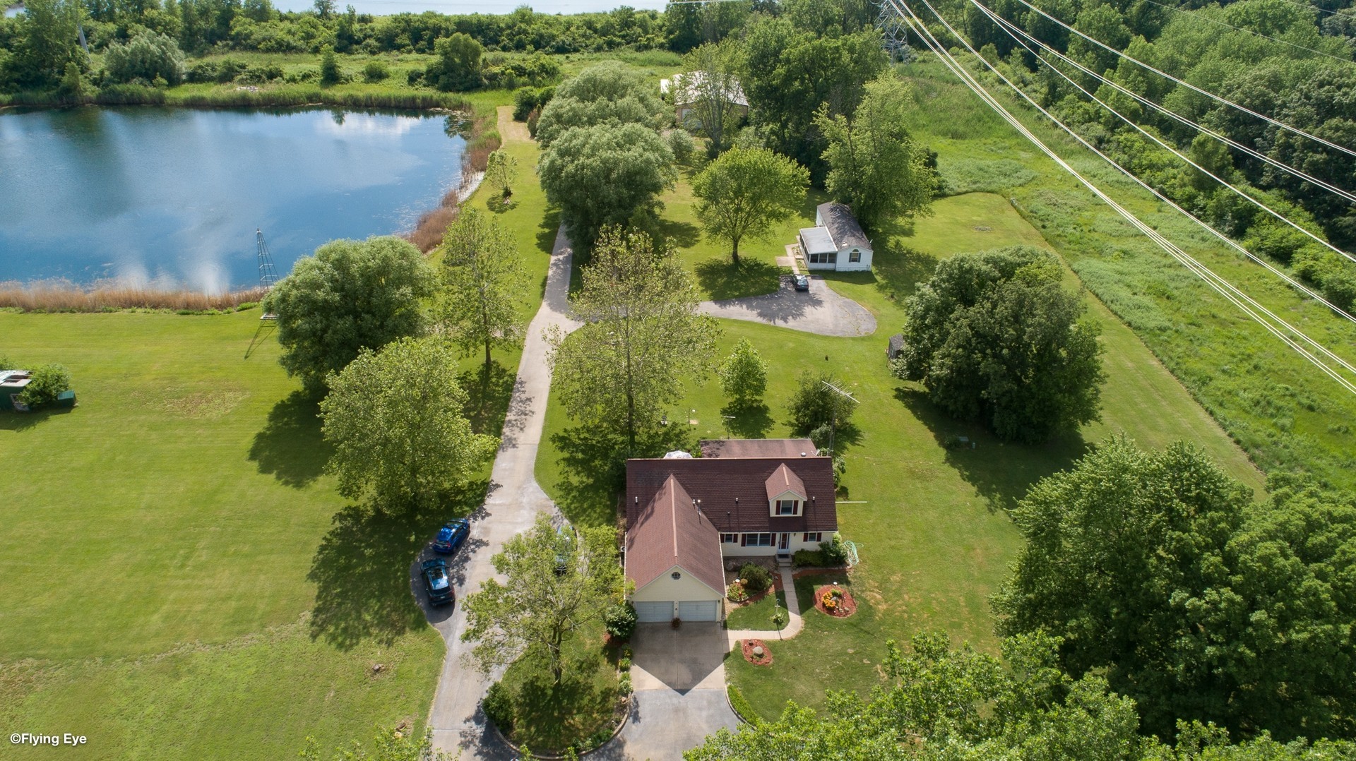 an aerial view of lake residential house with outdoor space and trees around