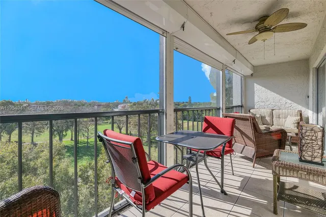 a view of a balcony with furniture and a floor to ceiling window