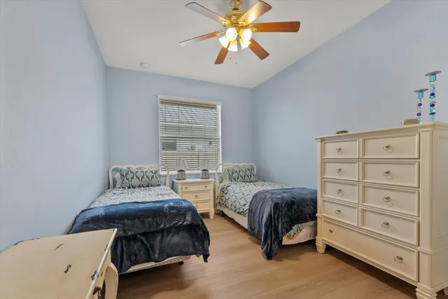 a bedroom with two beds and a chandelier