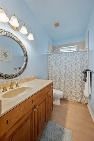 a bathroom with a granite countertop toilet a sink and a mirror