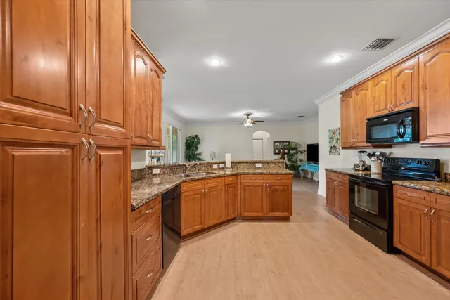 a kitchen with stainless steel appliances granite countertop wooden cabinets a sink and a stove
