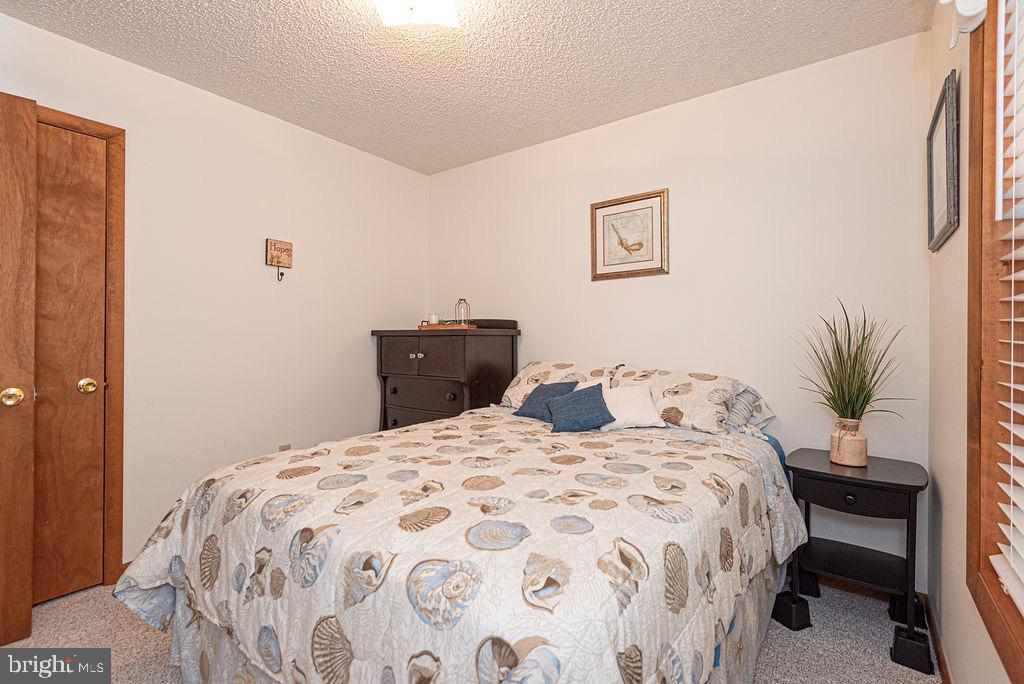 54 Abbyshire Road Ocean Pines, MD 21811 - Photo 17 of 43 a bedroom with a large bed and a potted plant