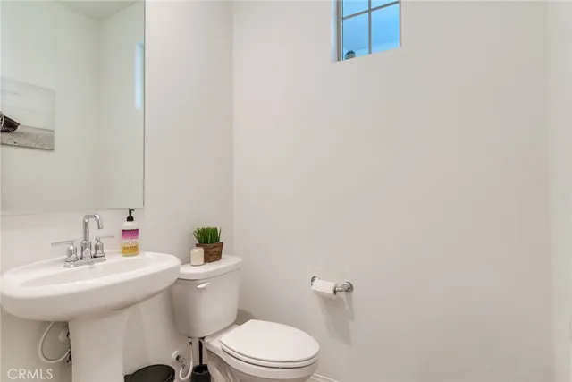 a bathroom with a sink a toilet and mirror