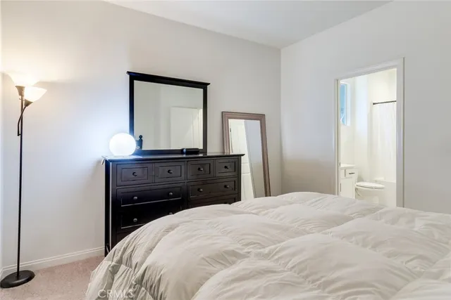 a bedroom with a bed and a mirror on dresser