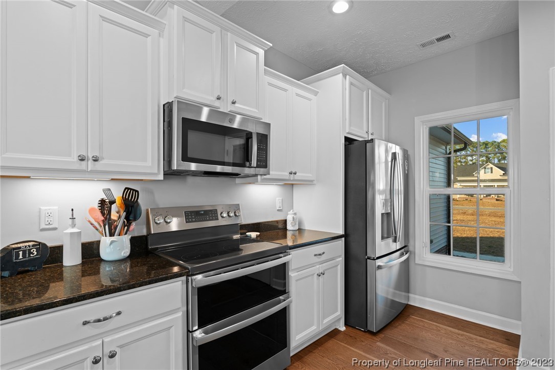 5654 Toby Pl Road Stedman, NC 28391 - Photo 11 of 42 a kitchen with stainless steel appliances granite countertop a refrigerator stove and sink