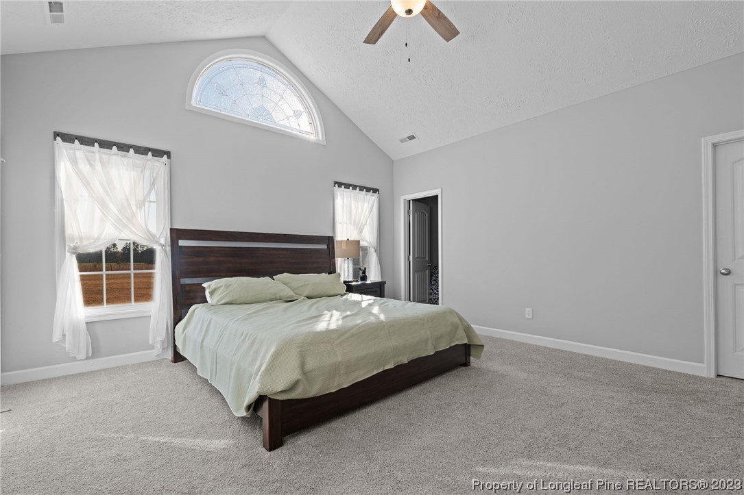 5654 Toby Pl Road Stedman, NC 28391 - Photo 16 of 42 a bedroom with a bed lamp and a large window