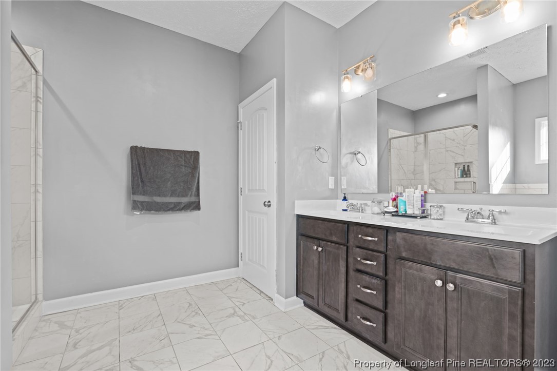 5654 Toby Pl Road Stedman, NC 28391 - Photo 19 of 42 a bathroom with a double vanity sink and a mirror