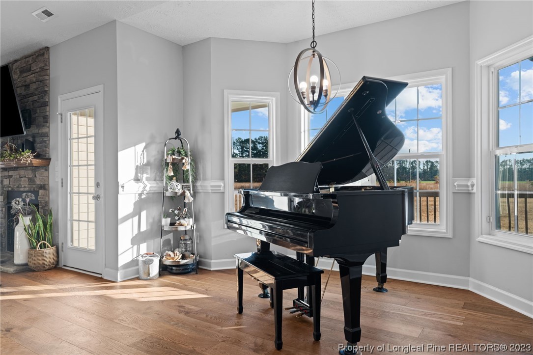 5654 Toby Pl Road Stedman, NC 28391 - Photo 8 of 42 a living room with furniture a piano and a chandelier